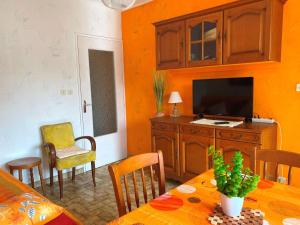 ein Wohnzimmer mit einem Esstisch und einem TV in der Unterkunft Appartement Balaruc-les-Bains, 1 pièce, 2 personnes - FR-1-553-251 in Balaruc-les-Bains