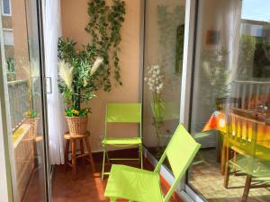einen Balkon mit grünen Stühlen sowie einem Tisch und Stühlen in der Unterkunft Appartement Balaruc-les-Bains, 1 pièce, 2 personnes - FR-1-553-251 in Balaruc-les-Bains