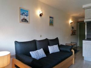 ein Wohnzimmer mit einem schwarzen Ledersofa in der Unterkunft Studio cabine avec balcon, parking, casier à ski, proche commodités et pistes à Villard-de-Lans - FR-1-548-42 in Villard-de-Lans