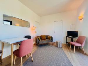 ein Wohnzimmer mit einem Tisch, Stühlen und einem Sofa in der Unterkunft Villa Quiberon, 2 pièces, 2 personnes - FR-1-478-285 in Quiberon