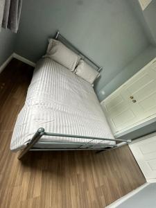 een bed met witte lakens en kussens in een kamer bij BNB Bed N Breakfast in Edinburgh