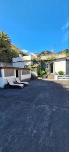 a parking lot with two chairs in front of a building at Valentina's House in Porto da Cruz