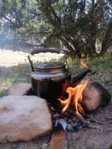 a pot sitting on top of a camp fire at Dana local life Eco Lodge in Dana