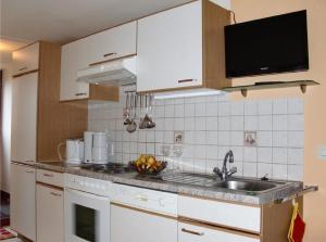 una cocina con armarios blancos y fregadero en Gemütliches Appartement in Abtenau mit Garten und Terrasse, en Abtenau