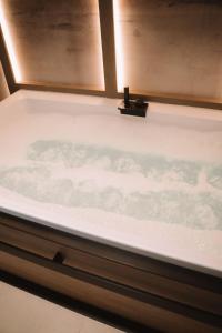 a bath tub in a bathroom with a window at Comàr suite in Monopoli
