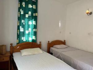 two beds in a room with green curtains at Apartment with sea view in Blue Bay, 125 m², near beach in Blue Bay