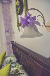 a lamp with a purple bow on top of a bed at Édes Otthon Vendégház in Nagybörzsöny