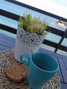 uma chávena de café azul e um vaso com flores em Estudio al Mar em San Marcos