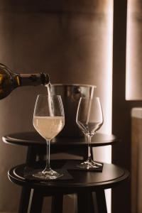 a bottle of wine being poured into two wine glasses at Comàr suite in Monopoli +14 photos