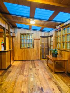 a large room with wooden floors and a blue ceiling at Guayabo Hostal Spa in Mindo
