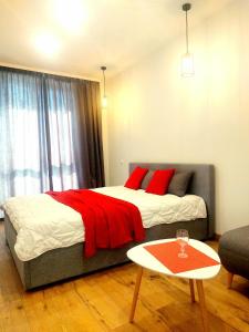 Un dormitorio con una cama con almohadas rojas y una mesa. en Новобудова ЗЕЛЕНА 261 Пасічна Сихівська en Leópolis