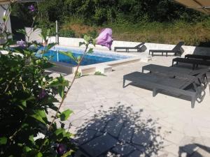 - une piscine avec 2 chaises longues et 2 bancs à côté dans l'établissement Ferienhaus in Mala Huba mit Privatem Pool, à Buzet