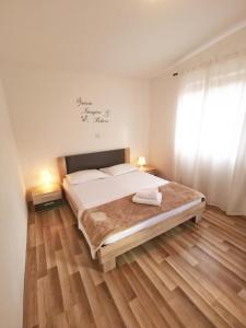- une chambre avec un grand lit et du parquet dans l'établissement Ferienhaus in Mala Huba mit Privatem Pool, à Buzet
