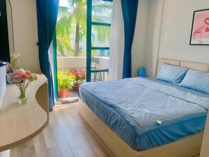 Schlafzimmer mit einem Bett mit blauer Bettwäsche und einem Fenster in der Unterkunft Minh Anh Hotel in Phu Quoc