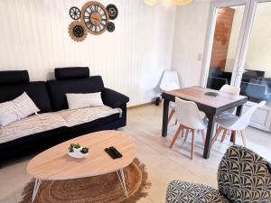 a living room with a couch and a table at Entre mer et foret 2 in Jard-sur-Mer