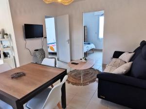 a living room with a couch and a table at Entre mer et foret 2 in Jard-sur-Mer