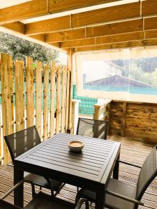 einen schwarzen Tisch und Stühle auf einer Holzterrasse in der Unterkunft Entre mer et foret 2 in Jard-sur-Mer + 7 Fotos