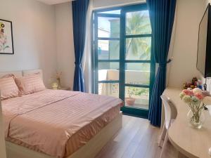 a bedroom with a bed and a table and a window at Minh Anh Hotel in Phu Quoc