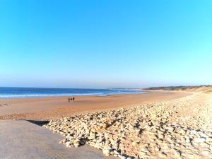 eine Gruppe von Menschen, die an einem Strand spazieren gehen in der Unterkunft Entre mer et foret 2 in Jard-sur-Mer
