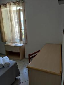 Cette chambre comprend une table, un lit et une fenêtre. dans l'établissement La Locanda del Convento, à Tropea