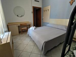 - une chambre avec un lit, une table et un miroir dans l'établissement La Locanda del Convento, à Tropea