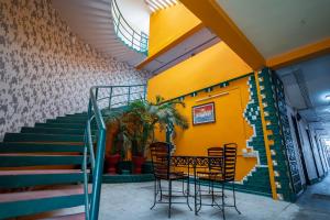 restauracja ze stołem, krzesłami i schodami w obiekcie La Courtyard w mieście Puducherry