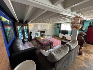 un soggiorno con due divani e una TV di Maison invitant aux voyages 20mn de la plage a Béziers