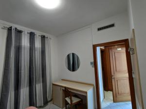 Cette chambre comprend une table, un miroir et une porte. dans l'établissement La Locanda del Convento, à Tropea