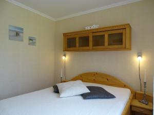 ein Schlafzimmer mit einem Bett mit einem hölzernen Kopfteil in der Unterkunft Moderne Ferienwohnung in Pudagla mit Grill, Garten und Terrasse in Pudagla