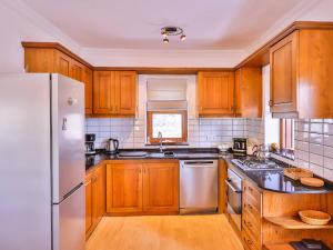 a kitchen with wooden cabinets and a white refrigerator at Villa Sarpedon in Kaş