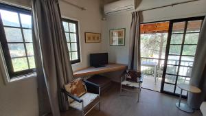 a room with a desk with a computer and two chairs at Calming Mountain View Apt with Balcony & Free Parking near Kakopetria in Nicosia