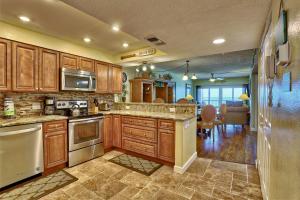 a kitchen with wooden cabinets and stainless steel appliances at Villa Madeira 404 - Premier in St. Pete Beach