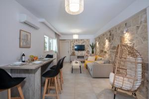 a living room with a kitchen and a living room with a couch at Elenas Village House - Love apartment with Pool and Terrace in Alikianós