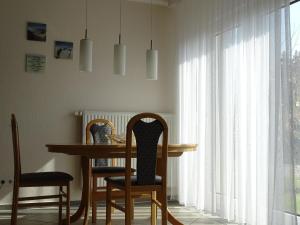 een eetkamer met een tafel en stoelen en een tafel en een raam bij Große Ferienwohnung in Pudagla mit Garten, Terrasse und Grill in Pudagla