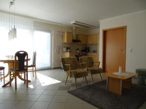 a living room with a table and chairs and a kitchen at Ferienwohnung 2 in Pudagla auf der Insel Usedom in Pudagla