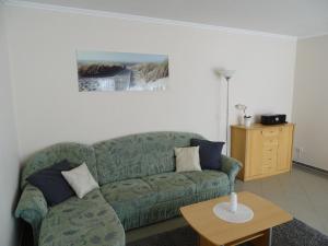 a living room with a green couch and a table at Ferienwohnung 2 in Pudagla auf der Insel Usedom in Pudagla