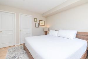 a white bedroom with a large white bed at Harbour Retreat in Victoria