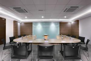 a conference room with a large table and chairs at Hotel Neo Gubeng by ASTON in Surabaya