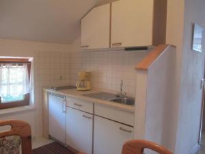a small kitchen with a sink and a refrigerator at Apartment für zwei Erwachsene und ein Kind mit Balkon in Bad Füssing