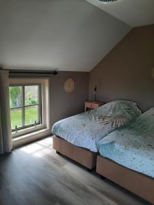 a bedroom with two beds and a window at zomerhuisje by the sea in Zoutelande