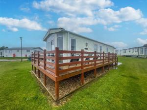a large bench in front of a mobile home at Lovely 6 Berth Caravan With Decking, Wifi And Onsite Beach Access Ref 68004cl in Lowestoft