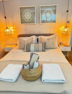 een bed met twee handdoeken en een mand erop bij Windsor Royal Retreat Luxury 1BED Apartment in Windsor