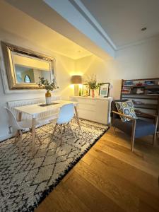 een woonkamer met een tafel en een spiegel bij Windsor Royal Retreat Luxury 1BED Apartment in Windsor