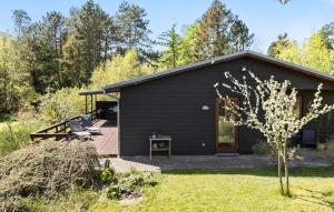 a black house with a deck and a yard at 2 Bedroom Lovely Home In Ebeltoft in Ebeltoft +16 photos