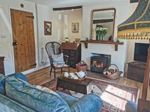 a living room with a couch and a fireplace at Earsdon Cottage in Ireby