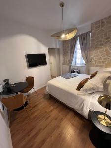 um quarto com uma cama, uma mesa e uma televisão em Studios Ani em Split