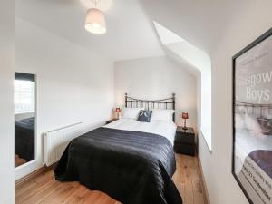 a bedroom with a bed with a black blanket at The Old Cheese Loft in Colfin