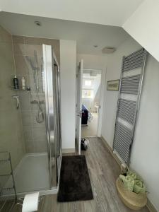 a bathroom with a walk in shower and a bath tub at Smith's Loft in Chichester