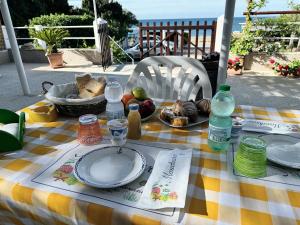 un tavolo con un piatto di cibo e un cesto di frutta di Mare Chiaro a Torre Vado