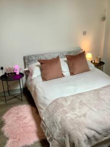 1 dormitorio con cama con almohadas y alfombra rosa en Luxury 1 Bed City Centre Apartment with Free Wifi & Breakfast en Liverpool